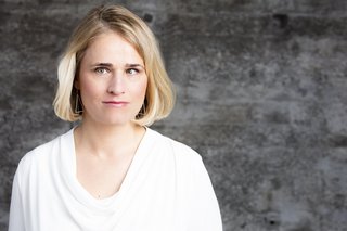 Das Portraitfoto zeigt VdK-Präsidentin Verena Bentele vor einem grauen Hintergrund.