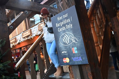 Schild vor einer Treppe von einem Restaurant mit dem Hinweis "Hier nur bargeldlos, nur Kartenzahlung, kein Bargeld"