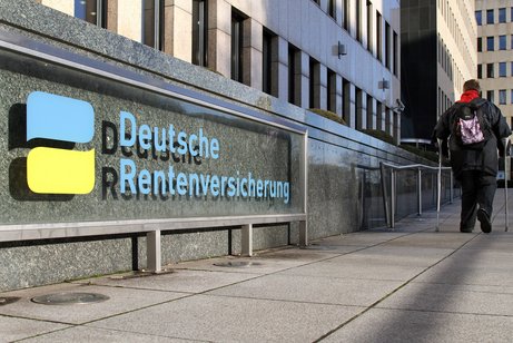 Eine Frau an Gehhilfen auf dem Weg zur Deutschen Rentenversicherung Berlin-Brandenburg, Standort Berlin.