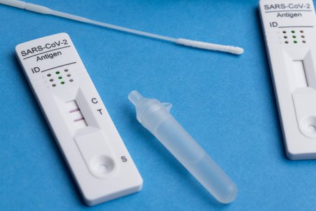 Ein positiver Corona-Test auf einer blauen Unterlage.