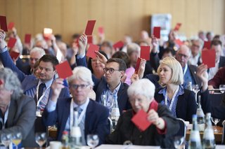 Blick in den Tagungssaal: Die Ordentlichen Delegierten des VdK-Bundesverbandstag halten ihre Stimmkarten hoch.