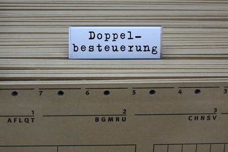 Hänge-Register mit Akten darin und einem Etikett "Doppelbesteuerung"
