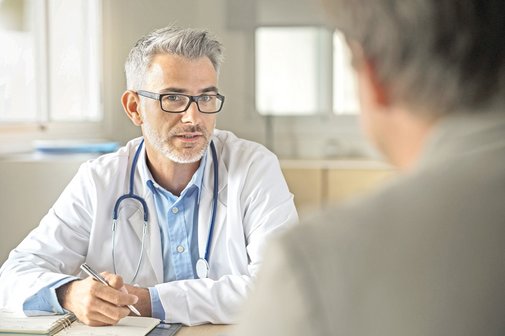 Ein Arzt spricht mit einem Patienten. 