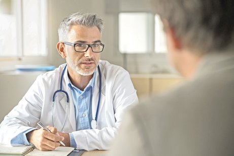 Ein Arzt spricht mit einem Patienten. 