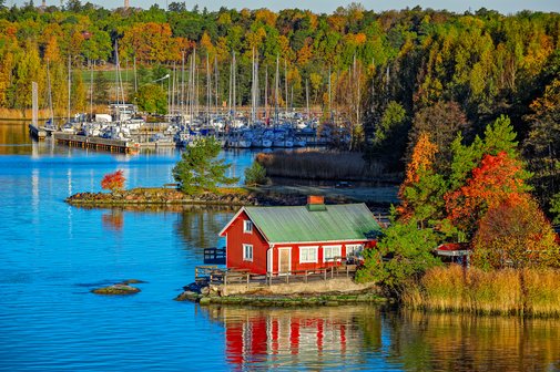 Rotes Haus an der felsigen Küste der Insel Ruissalo in Finnland.