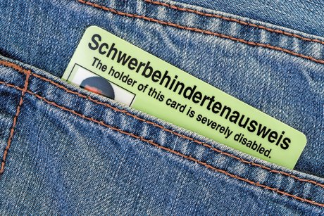 Ein Schwerbehindertenausweis in einer hinteren Jeanshosentasche.