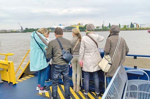 Ein Ausflug mit einem Schiff. Fünf Personen genießen den Ausblick vom Oberdeck.