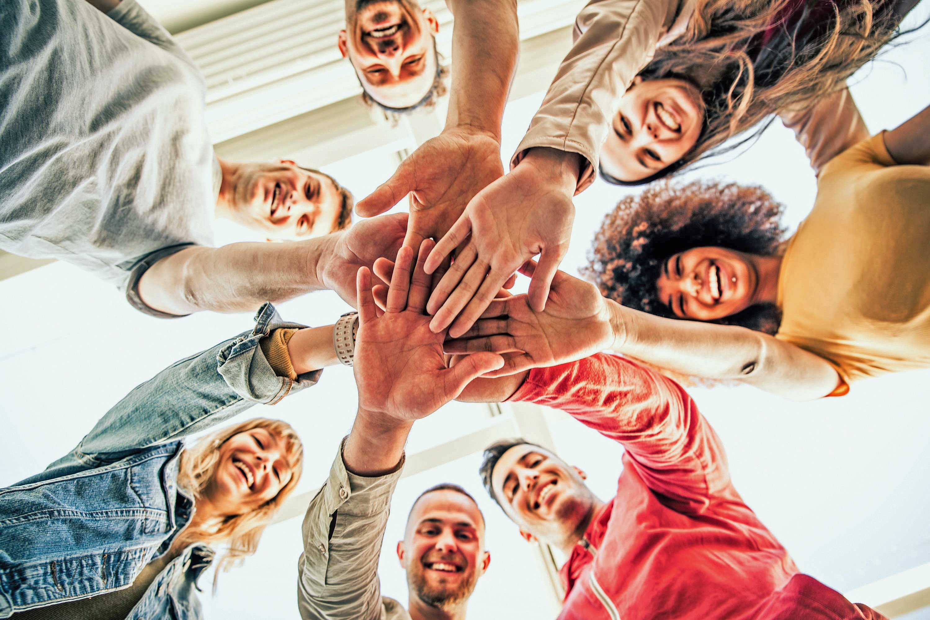 Mehr Vielfalt und Teilhabe im FSJ Kultur Junge, glückliche Menschen stapeln die Hände zusammen.