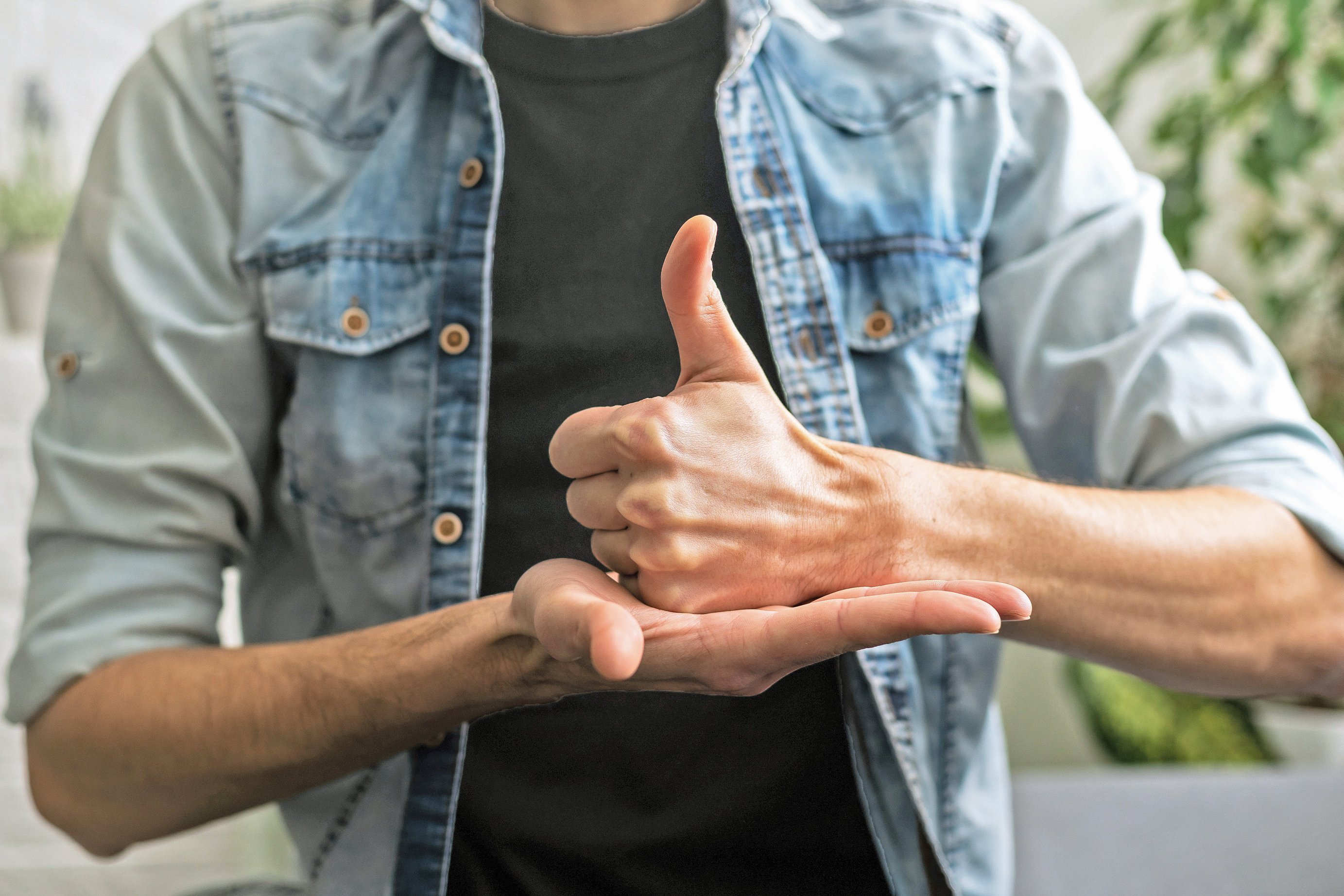 Gebärdendolmetscher im Vereinssport Gebärdensprachenzeichen mit flacher Hand, aufliegender Faust und aufgerichteten Daumen.