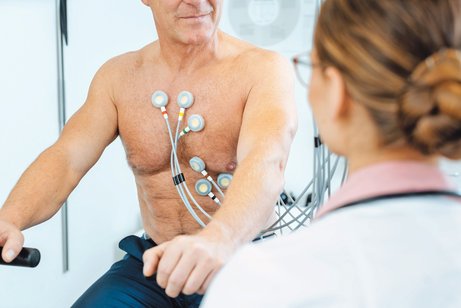 Ein Patient mit Elektroden am Oberkörper macht ein Belastungs-EKG.