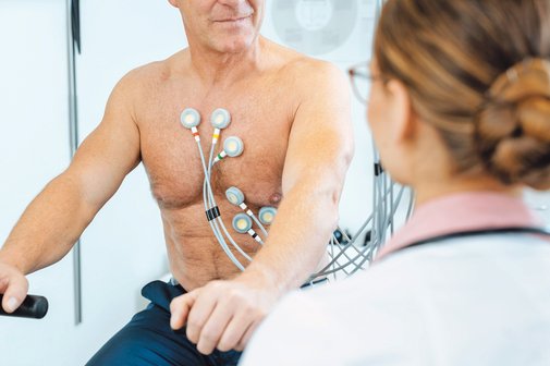 Ein Patient mit Elektroden am Oberkörper macht ein Belastungs-EKG.