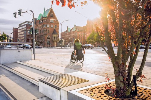 Eine Rollstuhlfahrerin fährt von der Hafencity Richtung alte Speicherstadt.