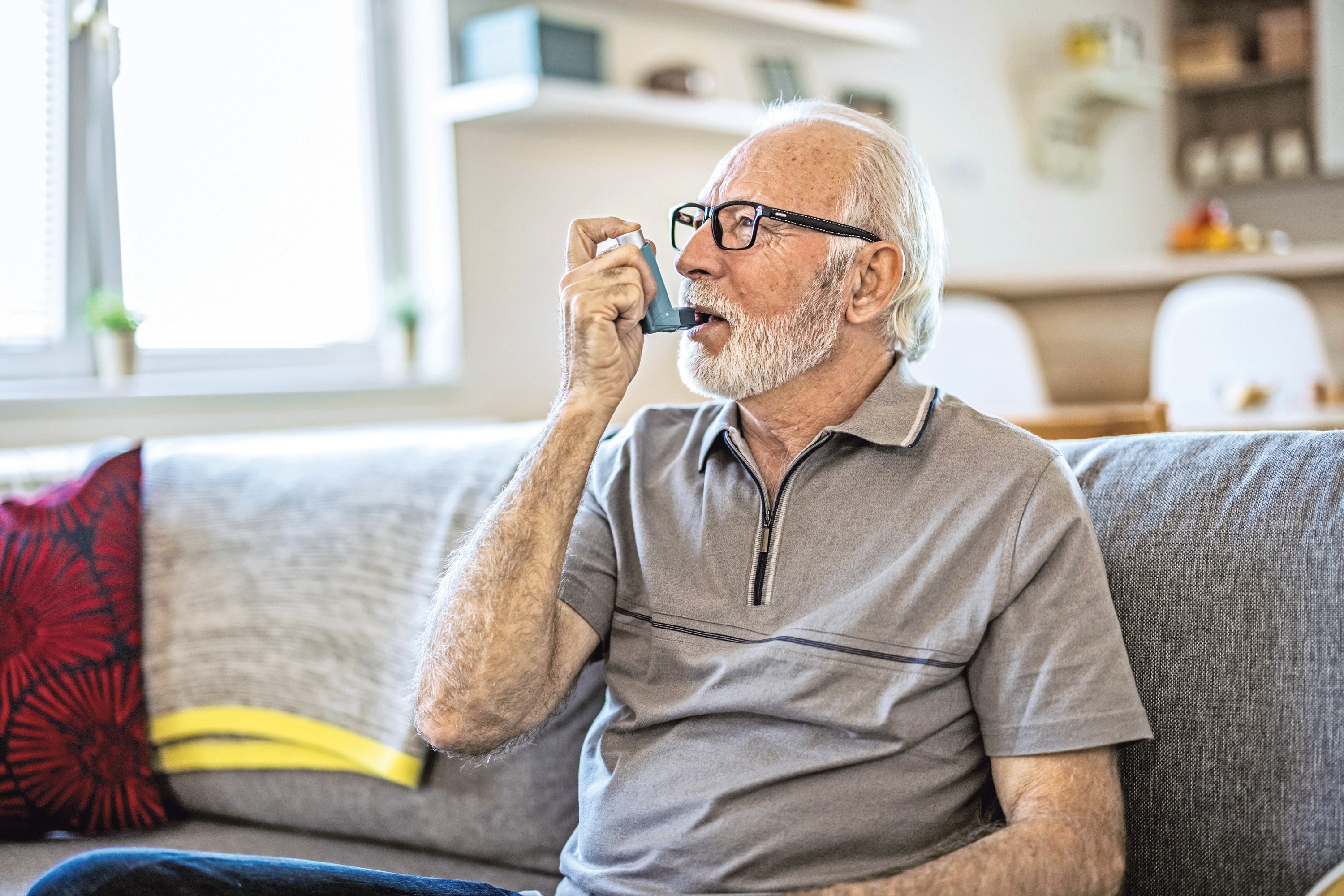 App für COPD-Erkrankte Ein älterer Mann verwendet ein medizinisches Inhalationsgerät, um seiner Allergie vorzubeugen und diese zu behandeln.