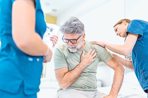 Pflegekr&auml;fte suchen bei einem Patienten nach Druckstellen.