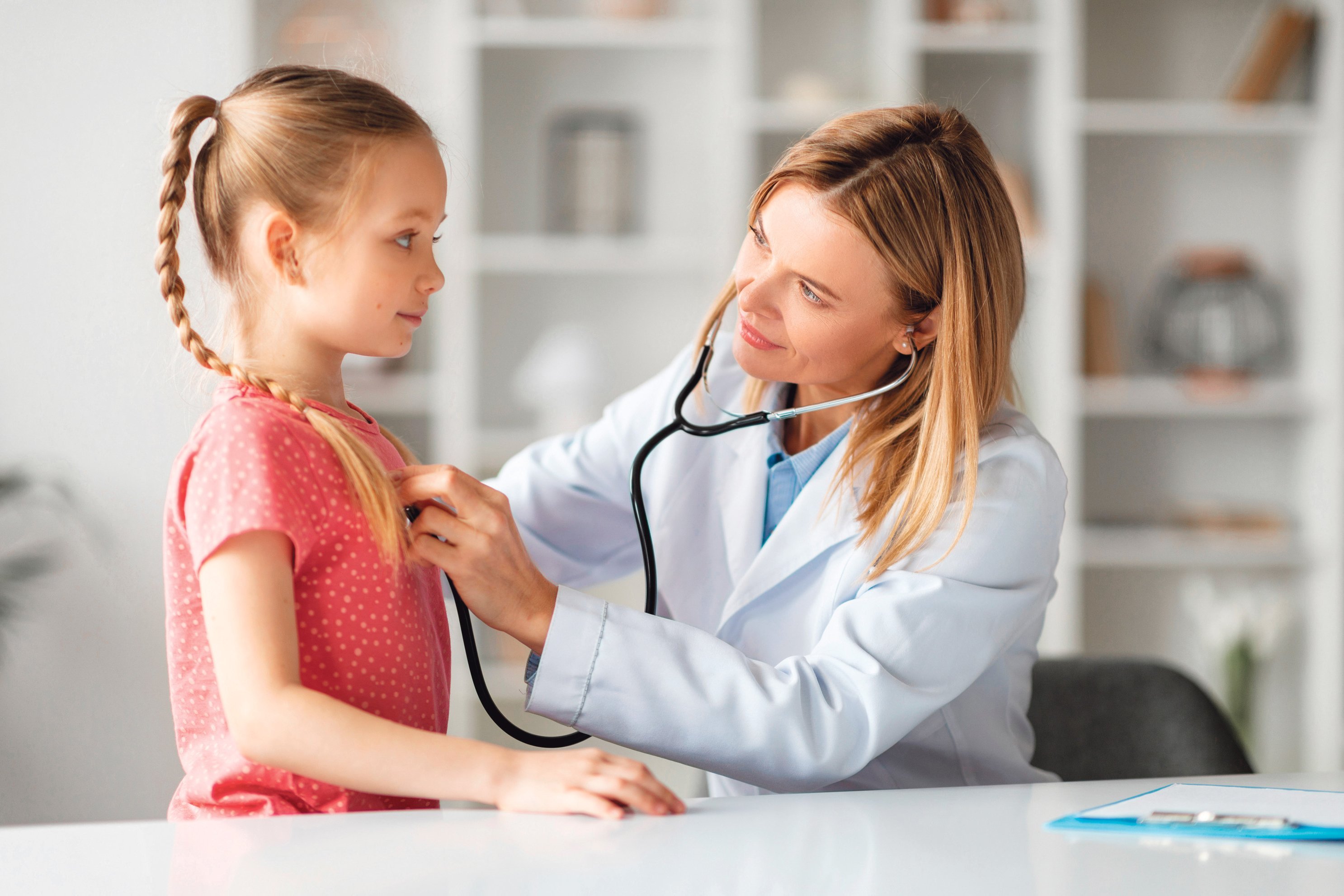 Eine &Auml;rztin untersucht ein M&auml;dchen.