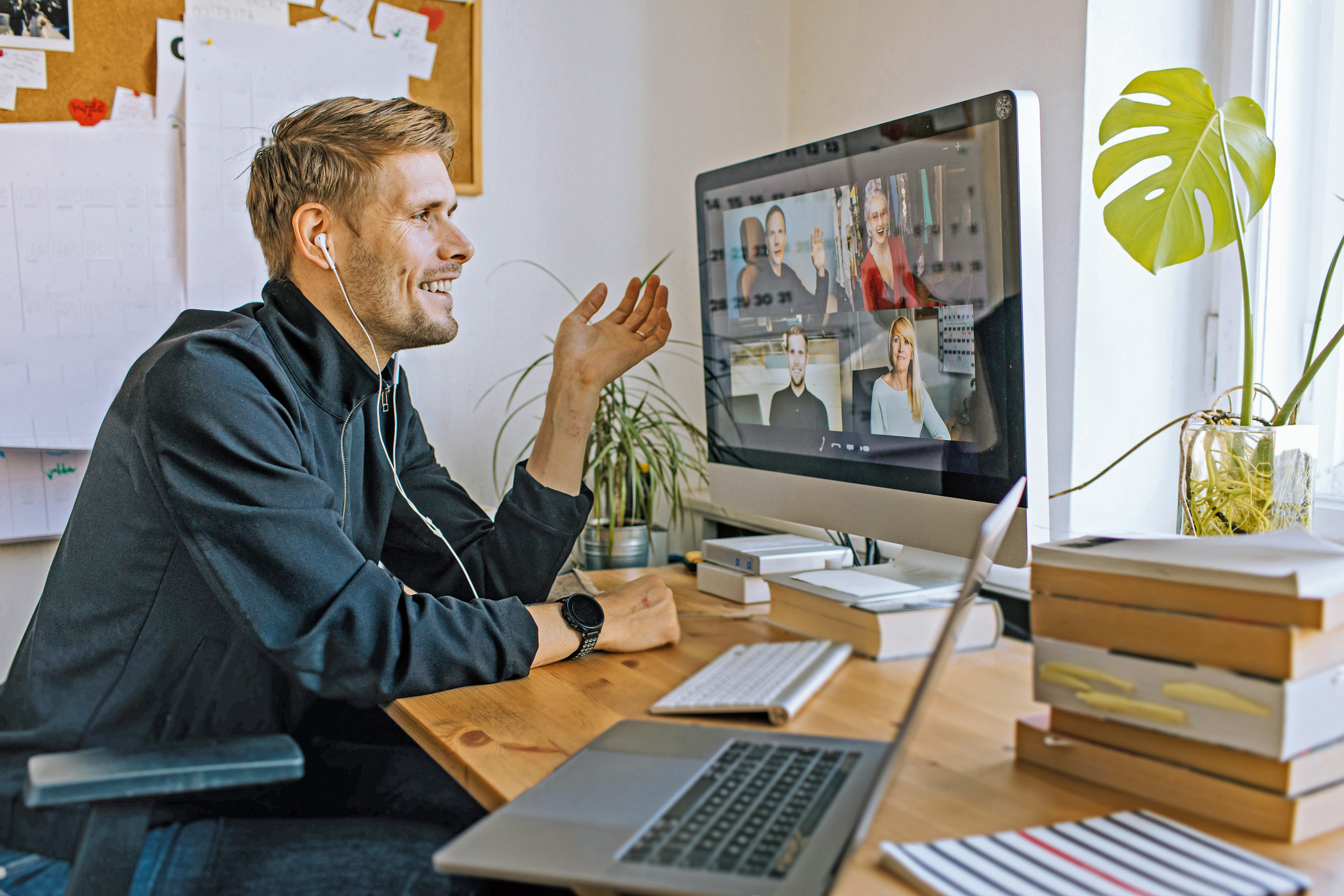 Einsamkeit am Arbeitsplatz Ein Mann sitzt an einem Schreibtisch und führt ein Videogespräch mit einigen anderen Personen.
