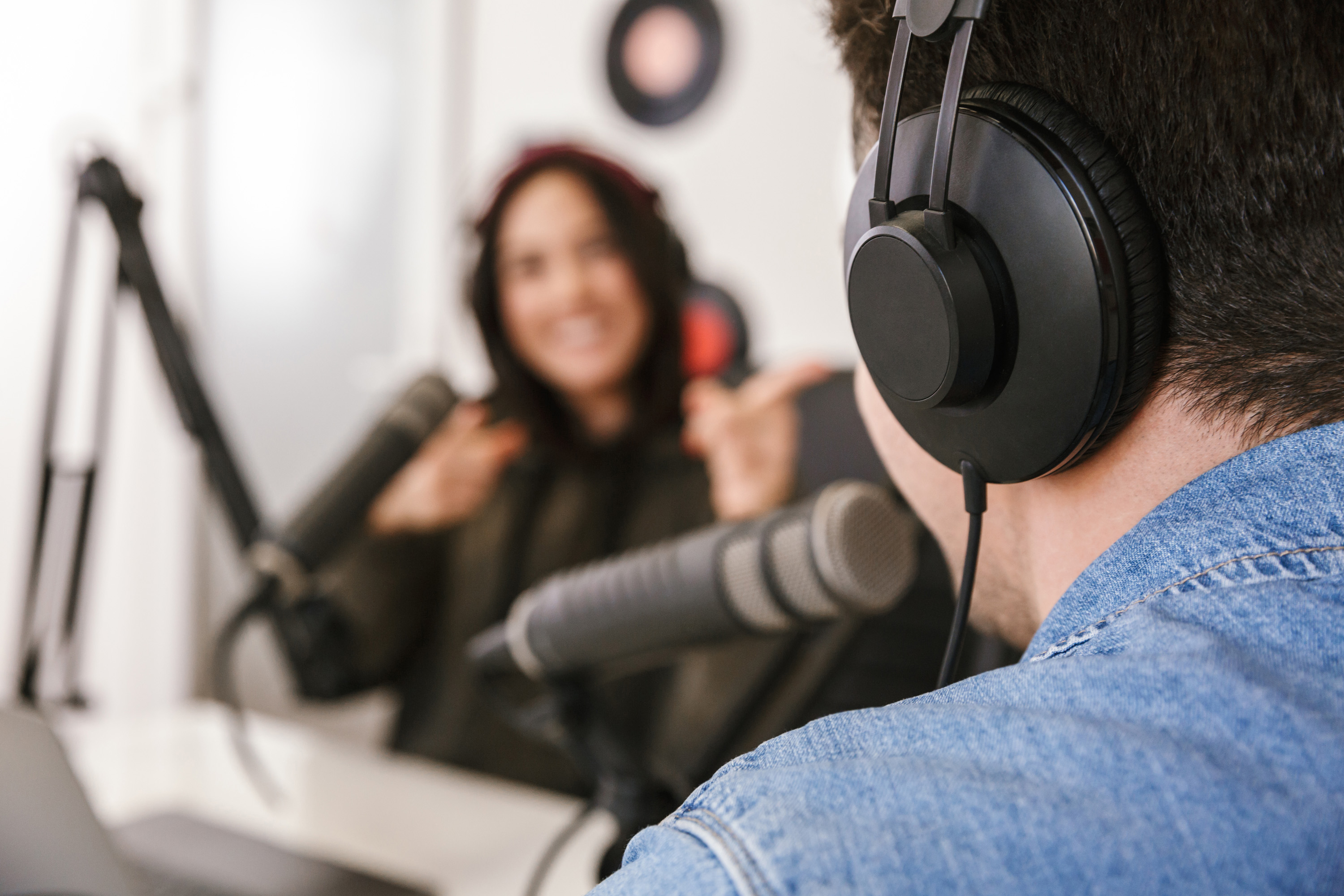 Podcast für Eltern von Grundschulkindern Ein Podcast mit einer Frau und einem Mann wird in einem Tonstudio aufgenommen.