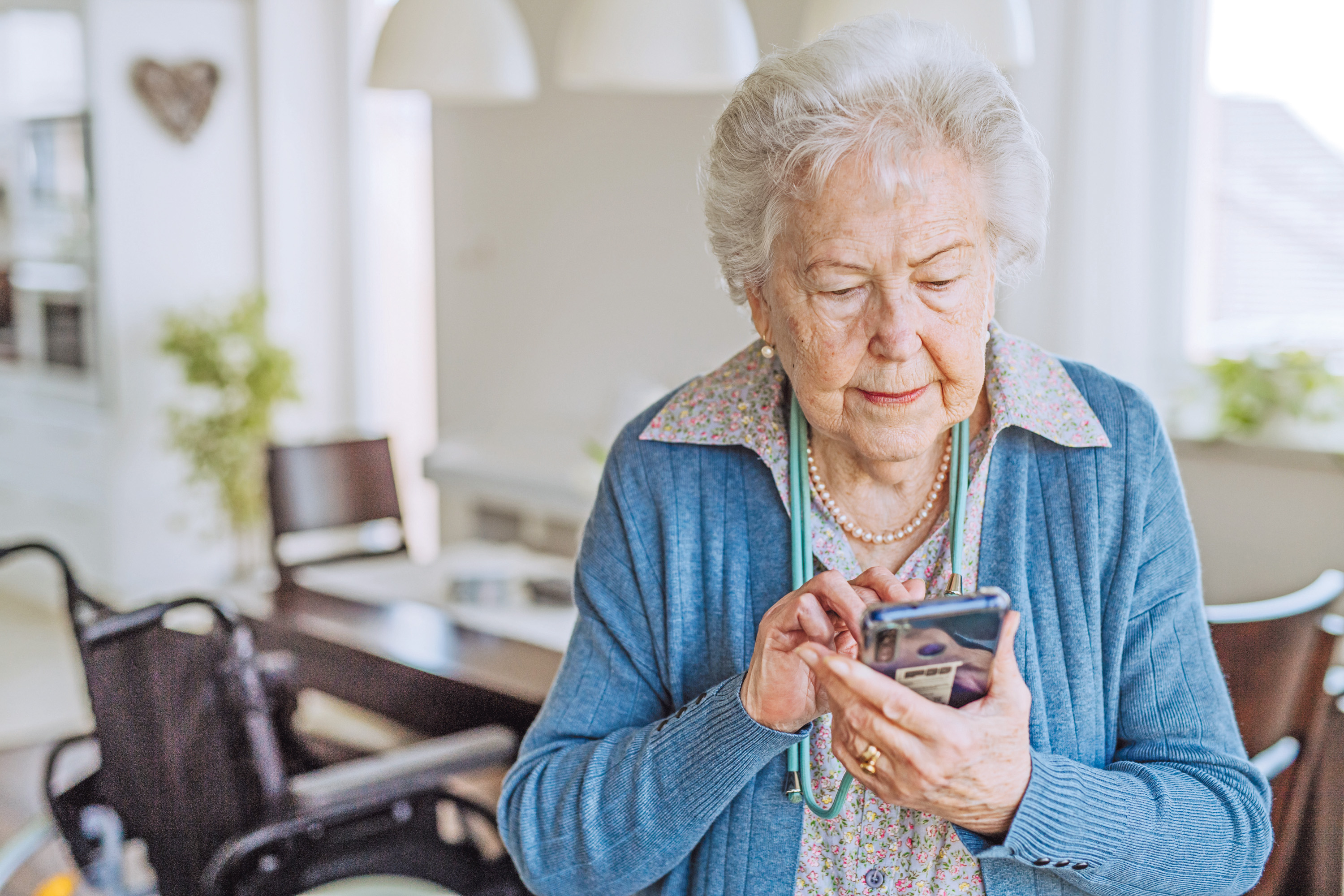 Eine &auml;ltere Frau stellt mit dem Smartphone einen Antrag auf Wohngeld.
